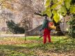 radnik Zelenila sakuplja opalo jesenje lišće duvačem lišća