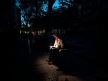 čovek sedi u mraku u Madridu tokom nestanka struje i čita knjigu uz led lampu