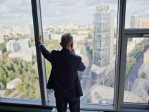 Biznismen posmatra grad iz kancelarije