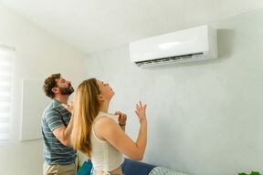 mladi par se hladi ispred klima uređaja