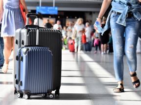 Putnici prolaze pored dva kofera na aerodromu