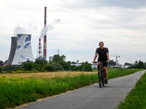 Biciklista prolazi pored elektrane na ugalj u Krakovu u Poljskoj