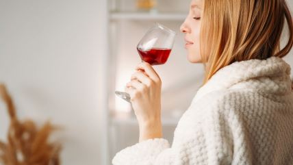 Devojka u belom bade mantilu pije vino
