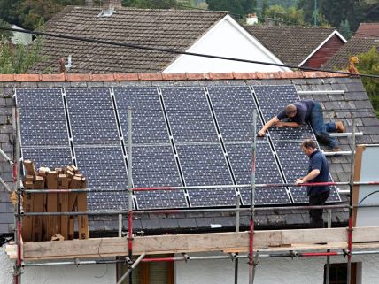 Radnici postavljaju solarne panele na krov kuće