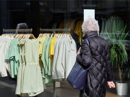 žena gleda u obaveštenje na kome piše da je prodavnica Esprit u Belgiji privremeno zatvorena