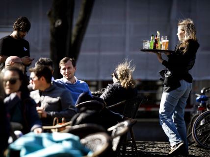 Konobarica uslužuje goste u kafiću u Holandiji