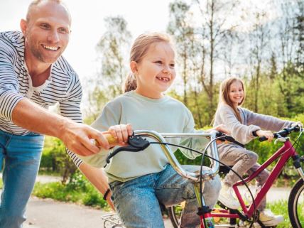 Otac uči ćerke da voze biciklu