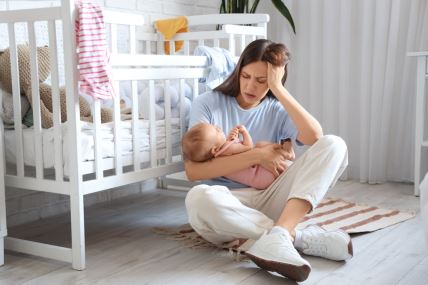 Majka sa simptomima depresije drži bebu u naručju