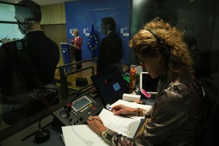 prevodilac sedi u kabini dok u pozadini govori Ursula fon der Lajen