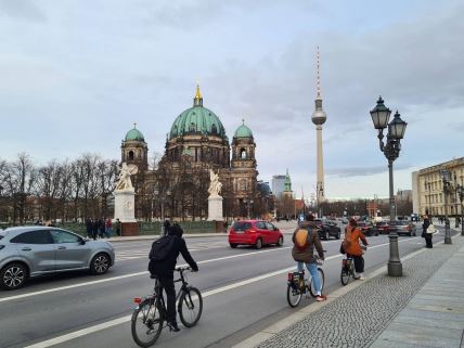 Troje biciklista vozi bicikl ulicama Berlina.