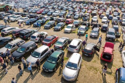 ljudi razgledaju polovne automobile