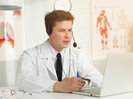 Doktor na kompjuterom i slušalicama