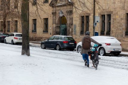 muškarac prolazi biciklom po snegu