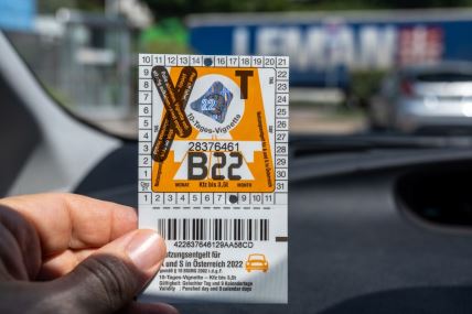 vozač u ruci drži vinjetu za kretanje austrijskim putevima