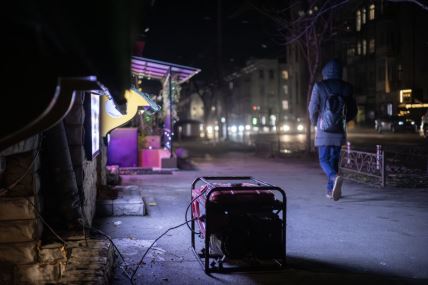 ljudi prolaze pored generatora u Kijevu tokom nestanka struje