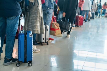 putnici čekaju u redu na aerodromu