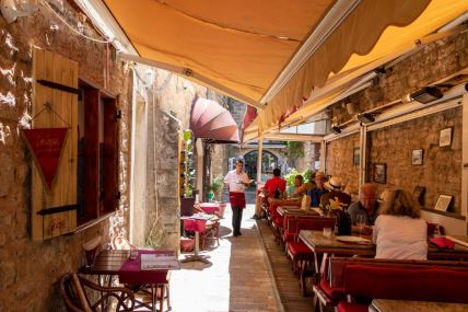 Ljudi sede u bašti restorana u Budvi