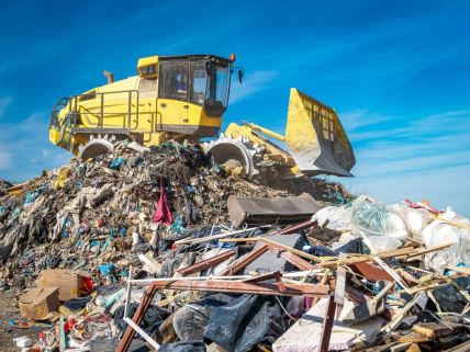 Bager razvrstava otpad na deponiji