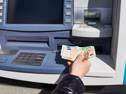 Žena podiže novac sa bankomata