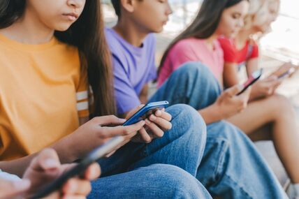 grupa tinejdžera gleda u mobilne telefone