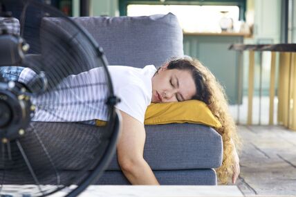 žena odmara ispred ventilatora usred velikih vrućina