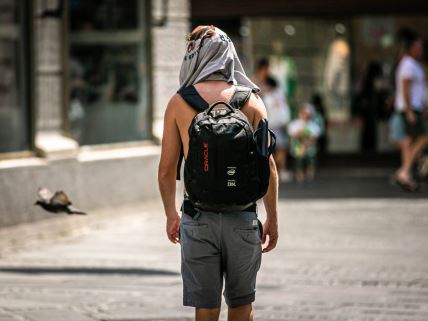 Muškarac šeta sa majicom od glave, štiteći se od vrućine u Beogradu