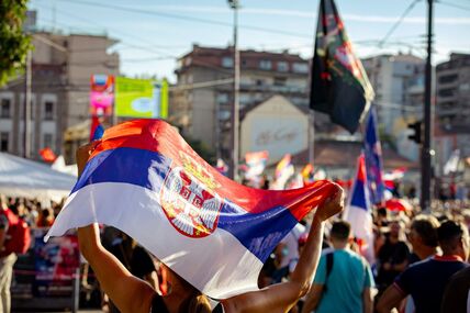 žena drži srpsku zastavu tokom studentskih protesta na Slaviji