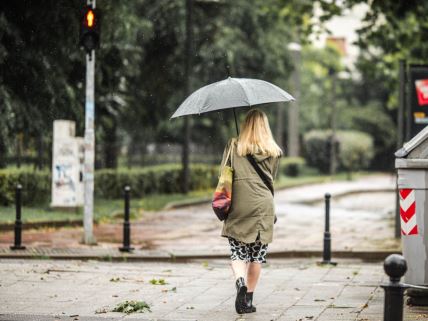 Žena drži kišobran dok šeta tmurnim Beogradom