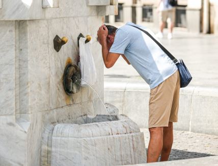 Muškarac se umiva na česmi u Beogradu tokom velikih vrućina