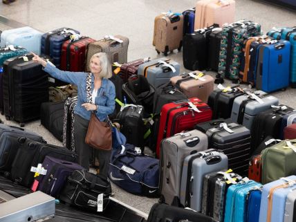 Žena se slika pored gomile prtljaga na aerodromu u atlanti nakog velikog pada sistema