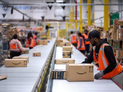 Radnici slažu kutije u jednom od Amazonovih skladišta u Evropi