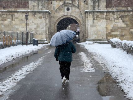 Osoba šeta sa kišobranom dok pada sneg u Beogradu