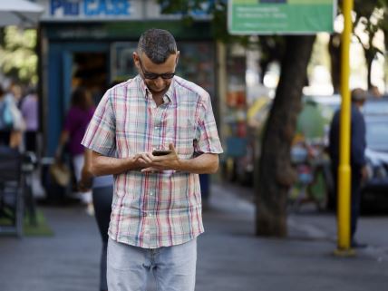 Čovek čita sadržaj sa mobilnog telefona