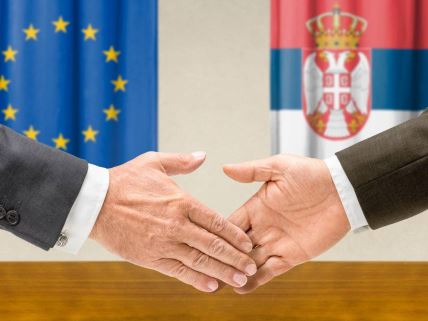 Zastave Srbije i EU i ruke.