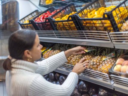 Žena ređa hranu u radnji u Milanu u kome se prodaje roba preostala od marketa ili kantina kako bi se snabdevali socijalno ugroženi građani