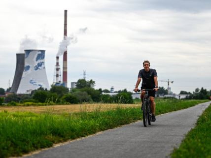 Biciklista prolazi pored elektrane na ugalj u Krakovu u Poljskoj