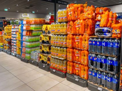 Sokovi u plastičnim ambalažama naređanim u paketima u supermarketu