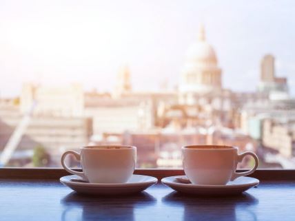 dve šoljice kafe iza kojih se vidi panorama Londona