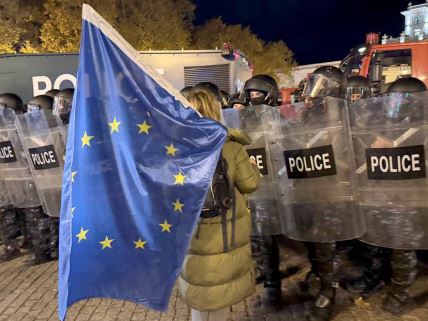 Demonstrantkinja sa zastavom EU ispred kordona policije