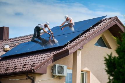 Radnici ugrađuju solarne panele na krov kuće