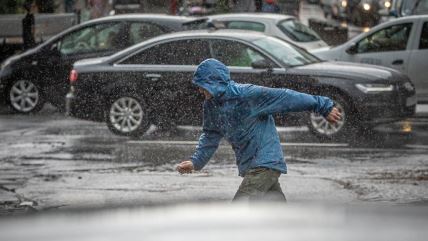 Muškarac po pljusku prelazi ulicu u Beogradu