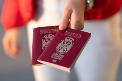 Žena drži dva srpska pasoša u ruci