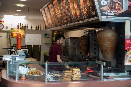 Radnik u lokalu u kome se služi doner kebab u Berlinu