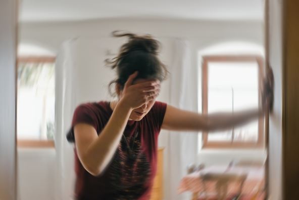 vrtoglavica, žena se drži za zid da ne padne