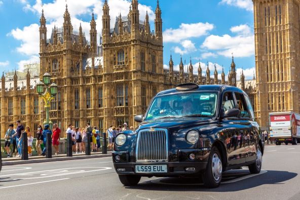 crno taksi vozilo u Londonu ispred Vestminsterske palate i Big Bena