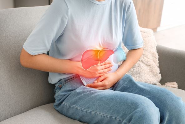 Čovek drži termofor i greje predeo jetre