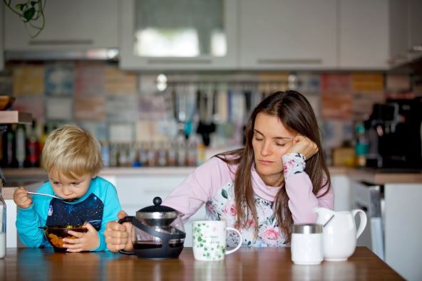 umorna majka sedi pored sina