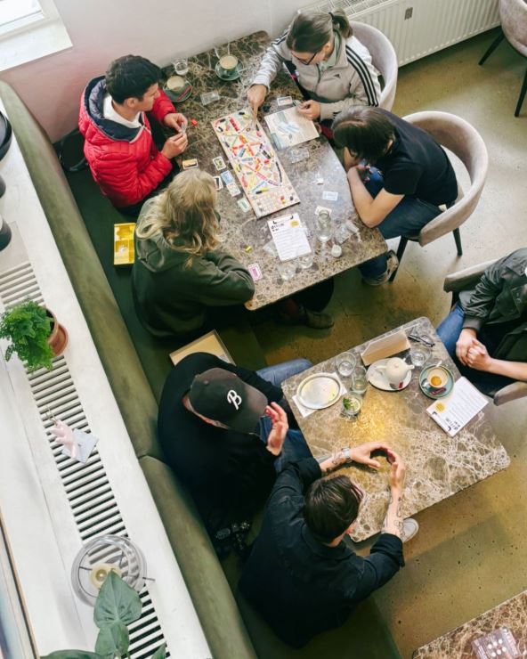 ljudi sede u kafiću za digitalni detoks i igraju društvene igre