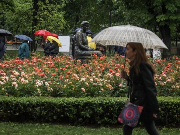 Ljudi sa kišobranima po kišnom danu prolaze parkom Tašmajdan