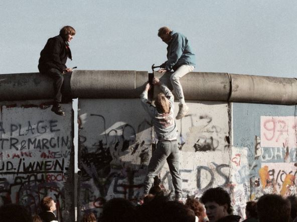 Ljudi se penju na Berlinski zid 1989. godine